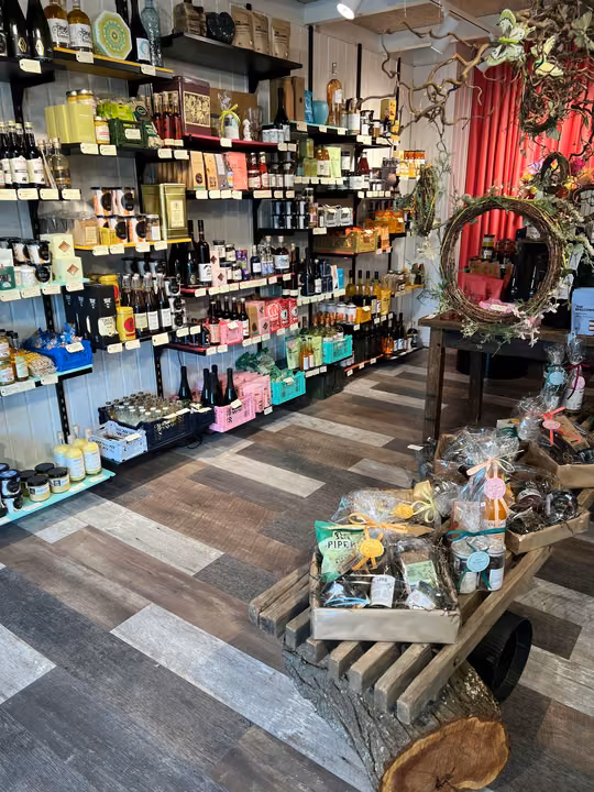 Hylder med flasker, delikatesser og små gaveidéer i butikken