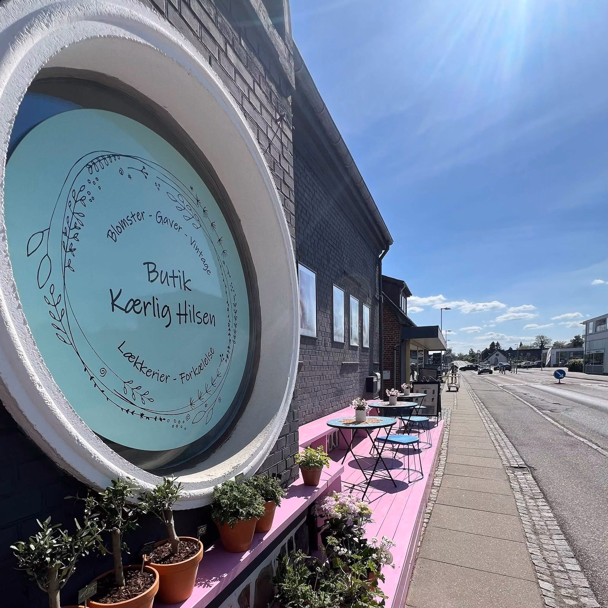 Butik Kærlig Hilsen på Grenåvej med blomster og rosa udstilling foran butikken